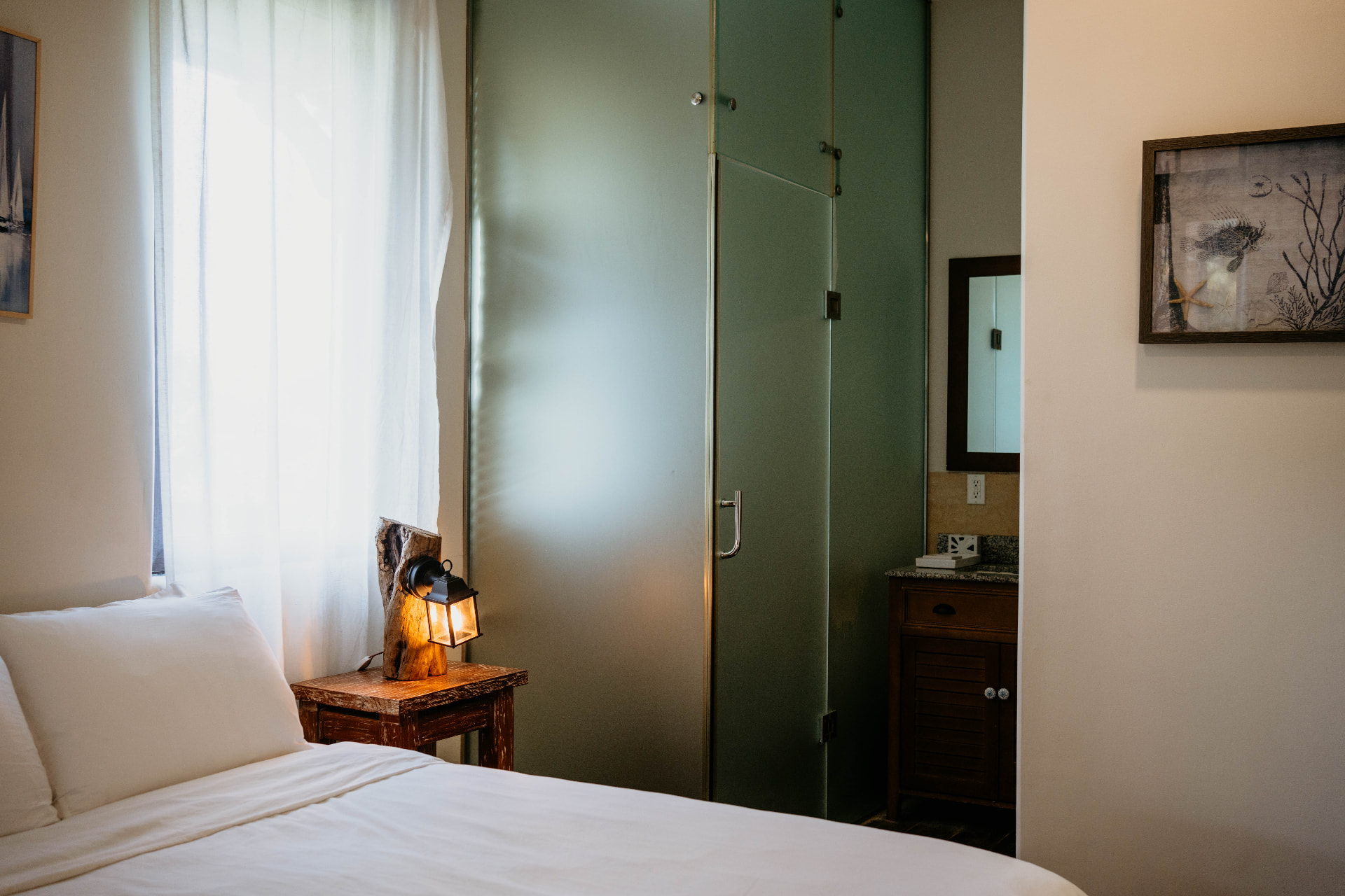 Apartment B21 — bedroom with lantern lamp and glass-enclosed bathroom