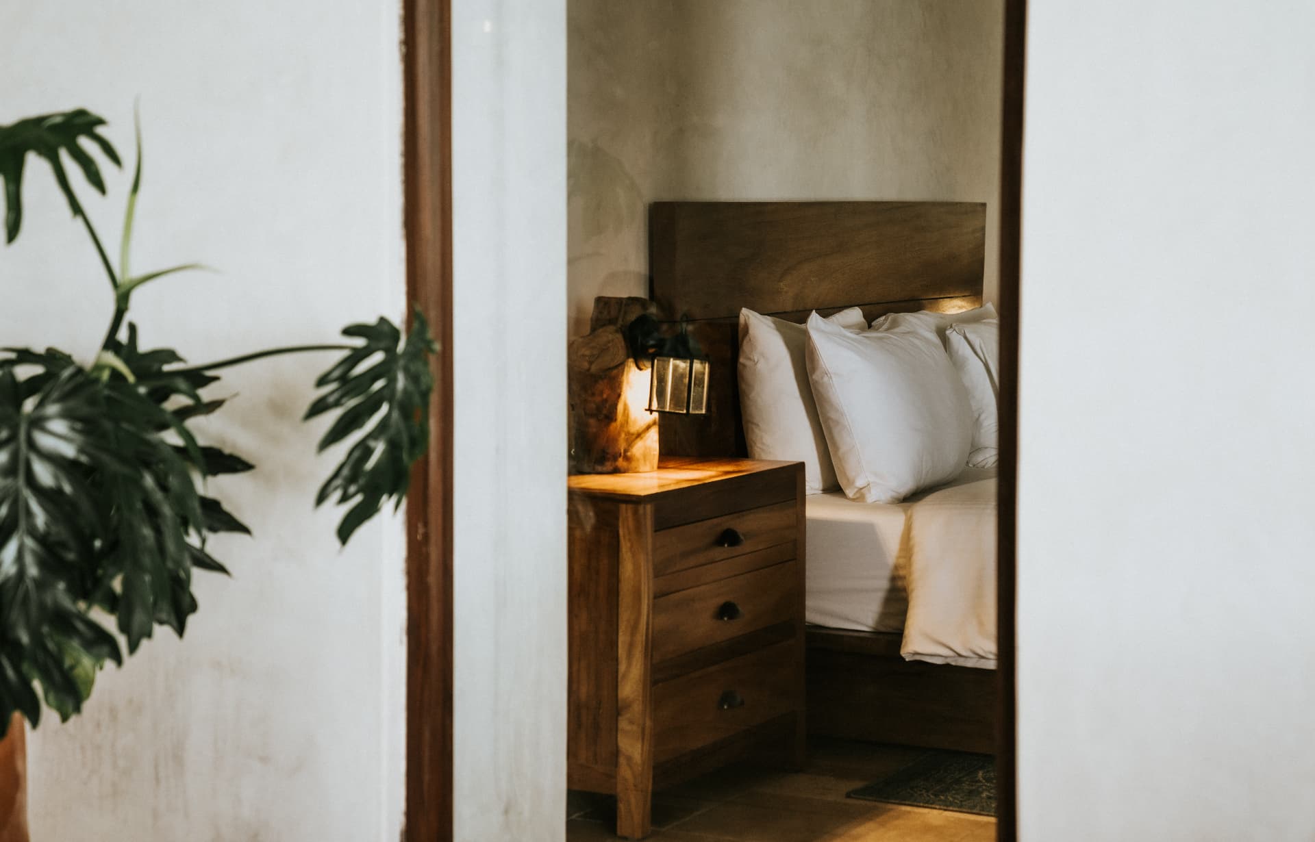 Villa Nomada — bedroom glimpsed through a wooden doorway