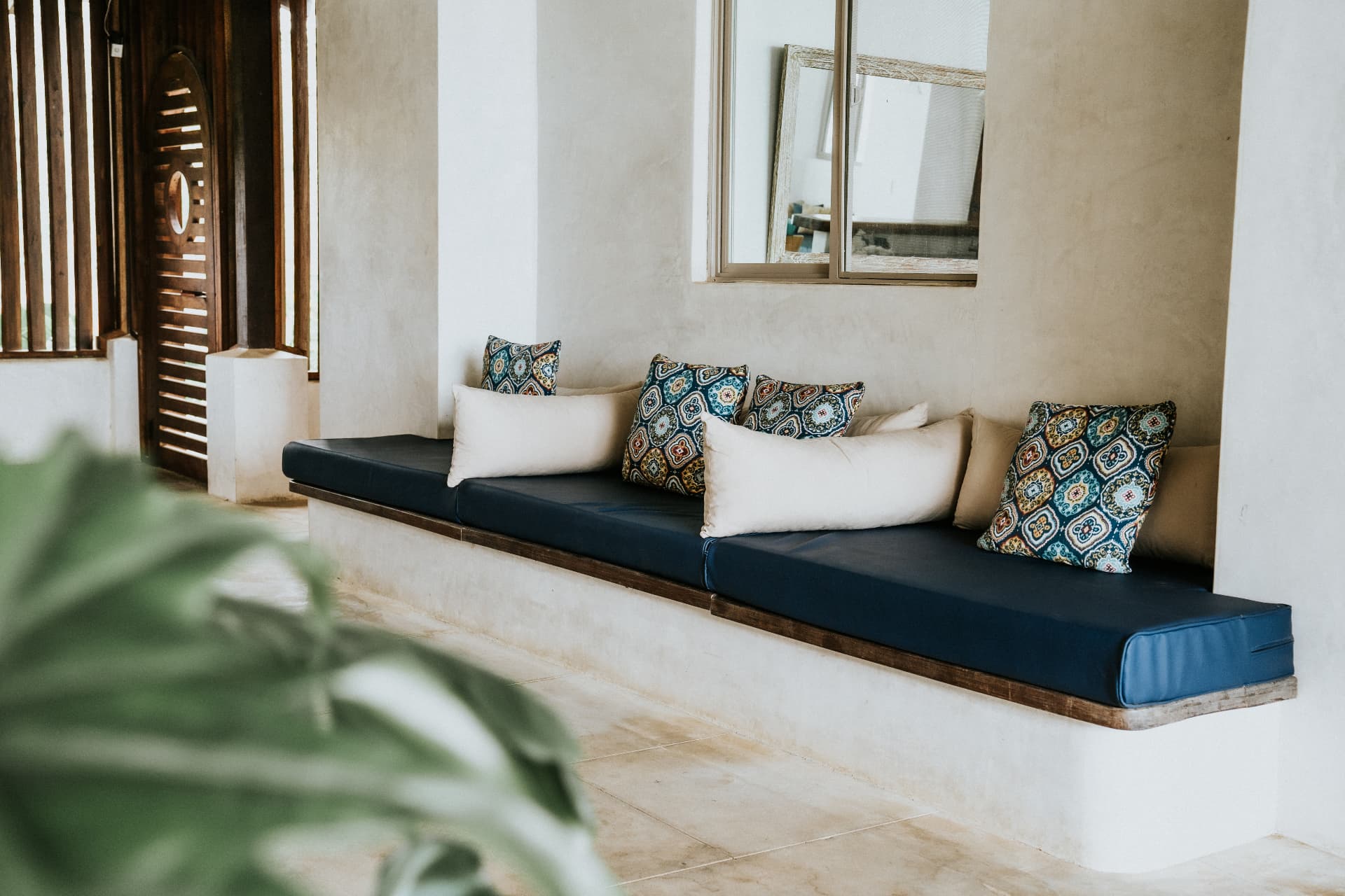 Villa Nomada — long built-in bench with blue cushions and patterned pillows