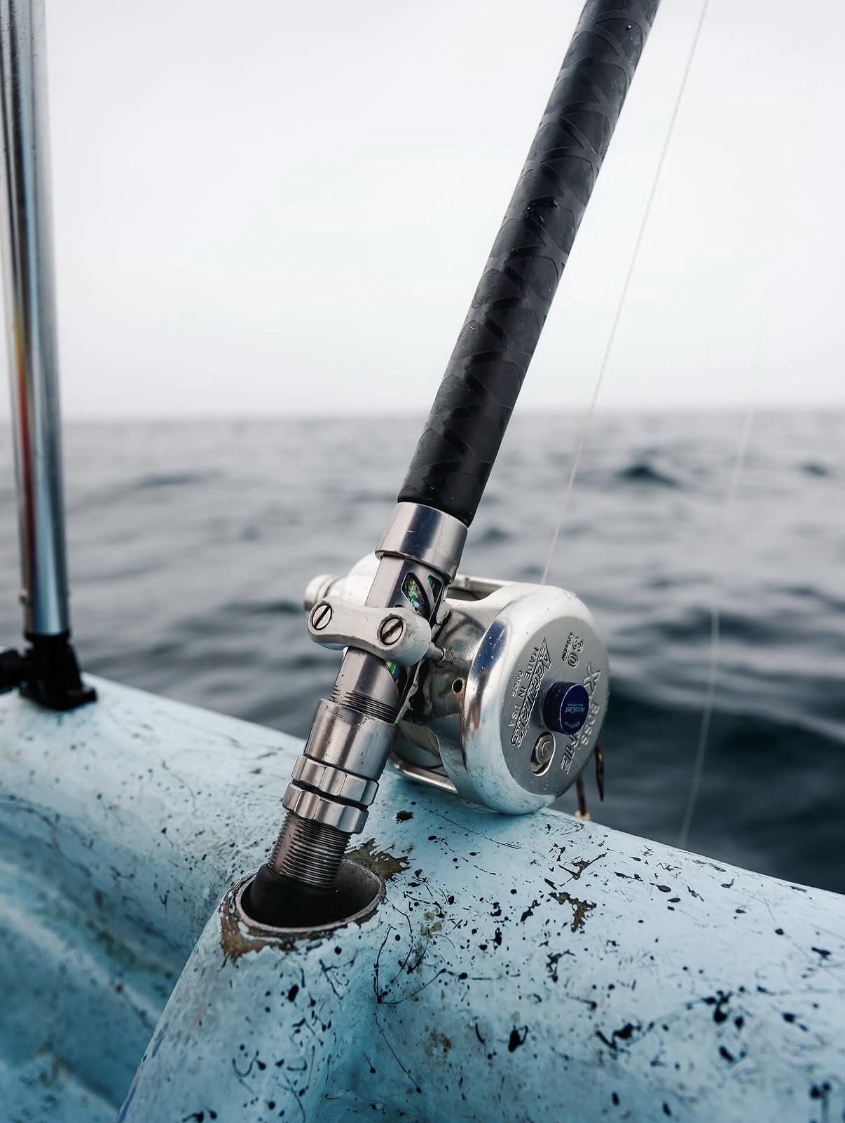 A fishing rod and reel set in the gunwale of a small boat