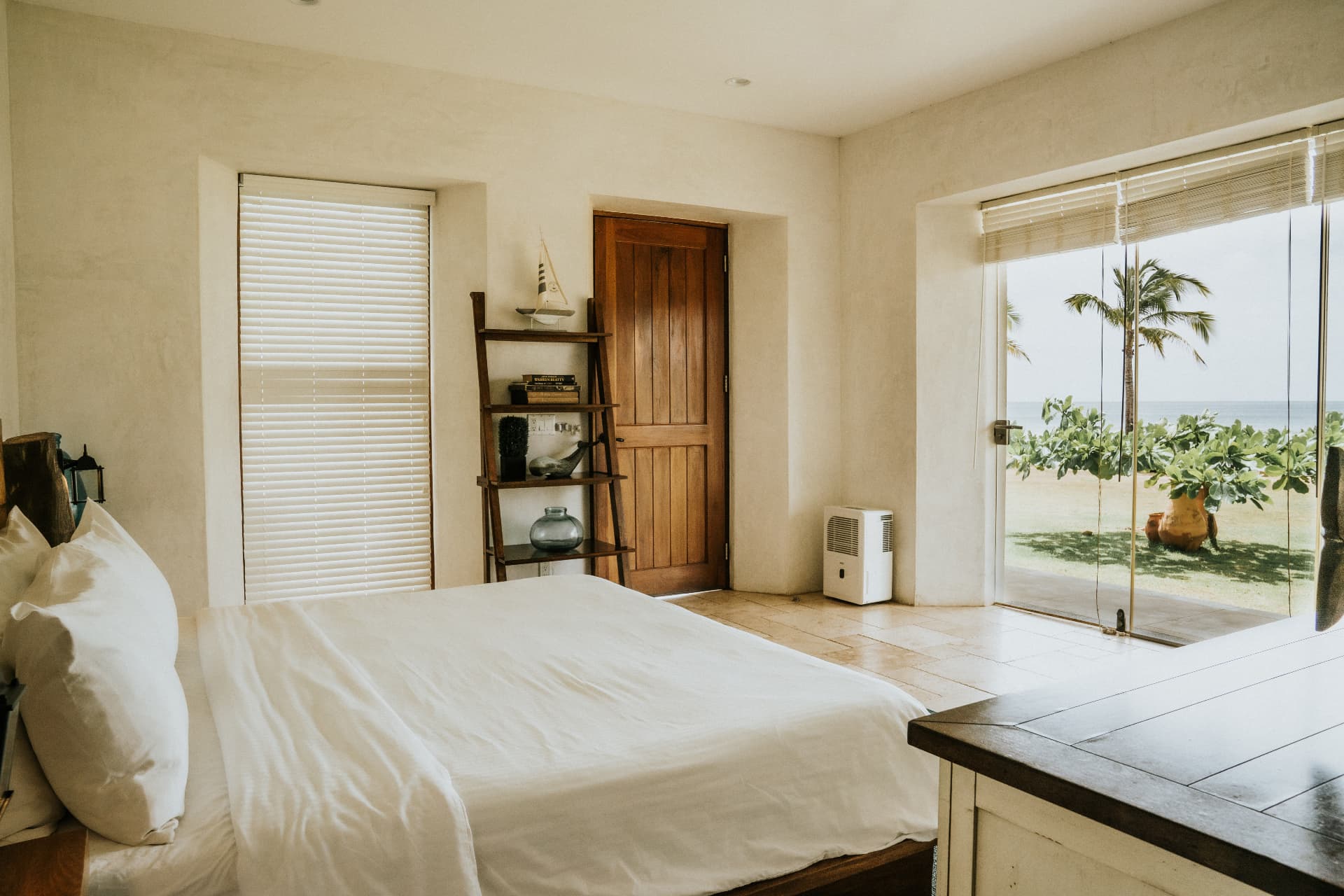 Villa Nomada — master bedroom with sliding doors open to palms and the ocean