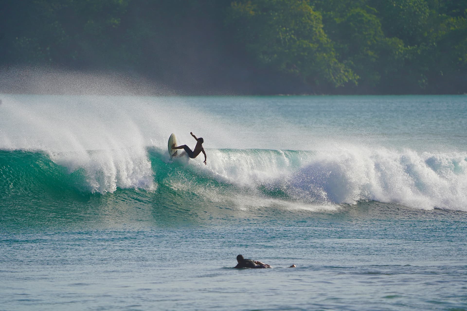 A surfer on a clean green wave at Playa Venao