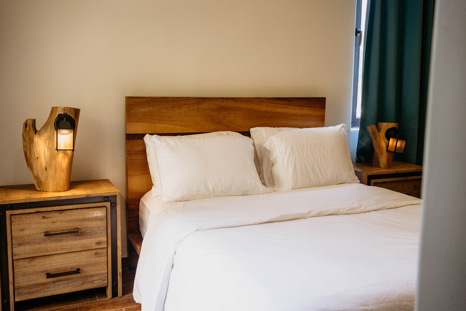 Apartment A18 — bedroom with wooden headboard, white bedding and lantern lamps