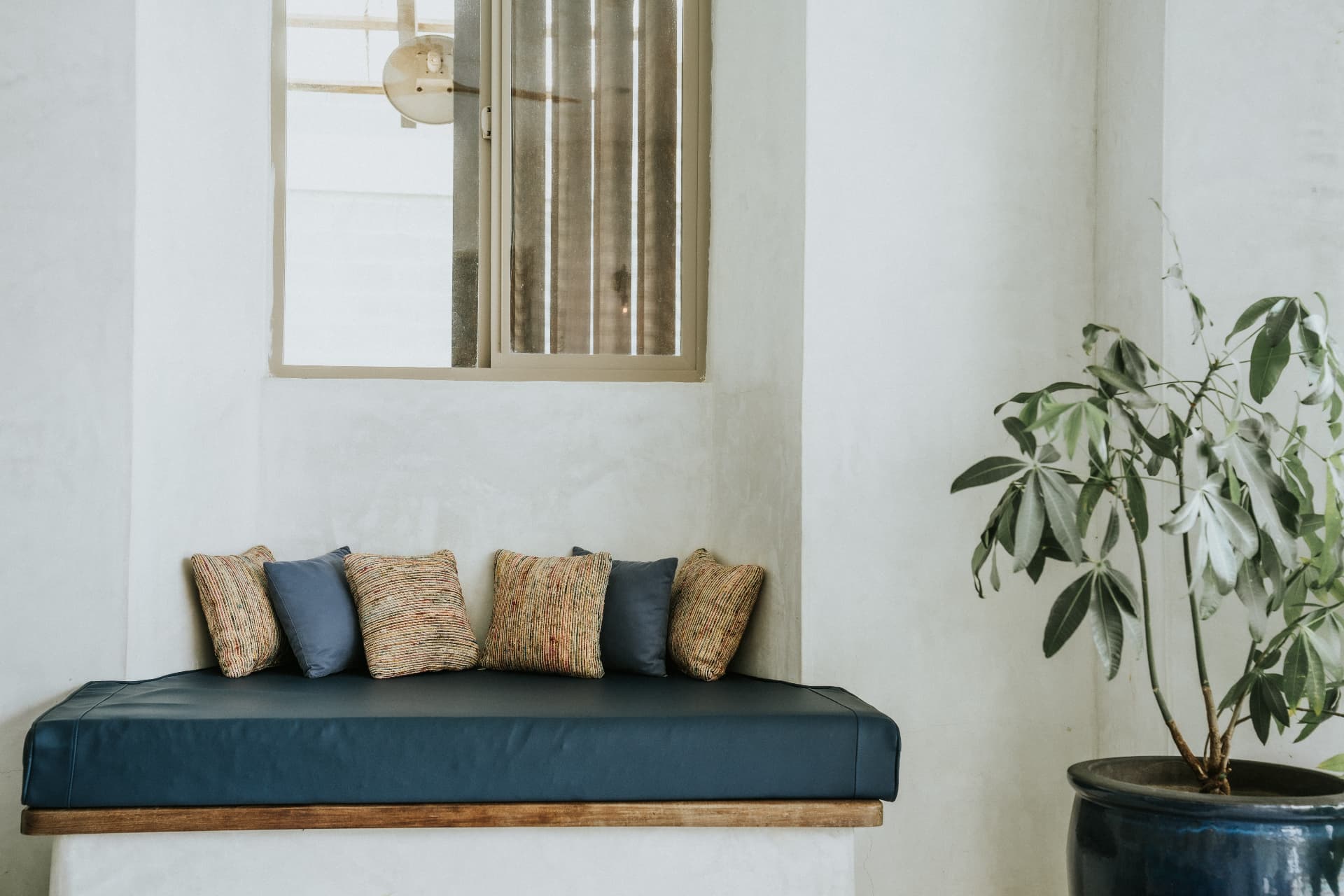 Villa Nomada — built-in bench with woven cushions beneath a window