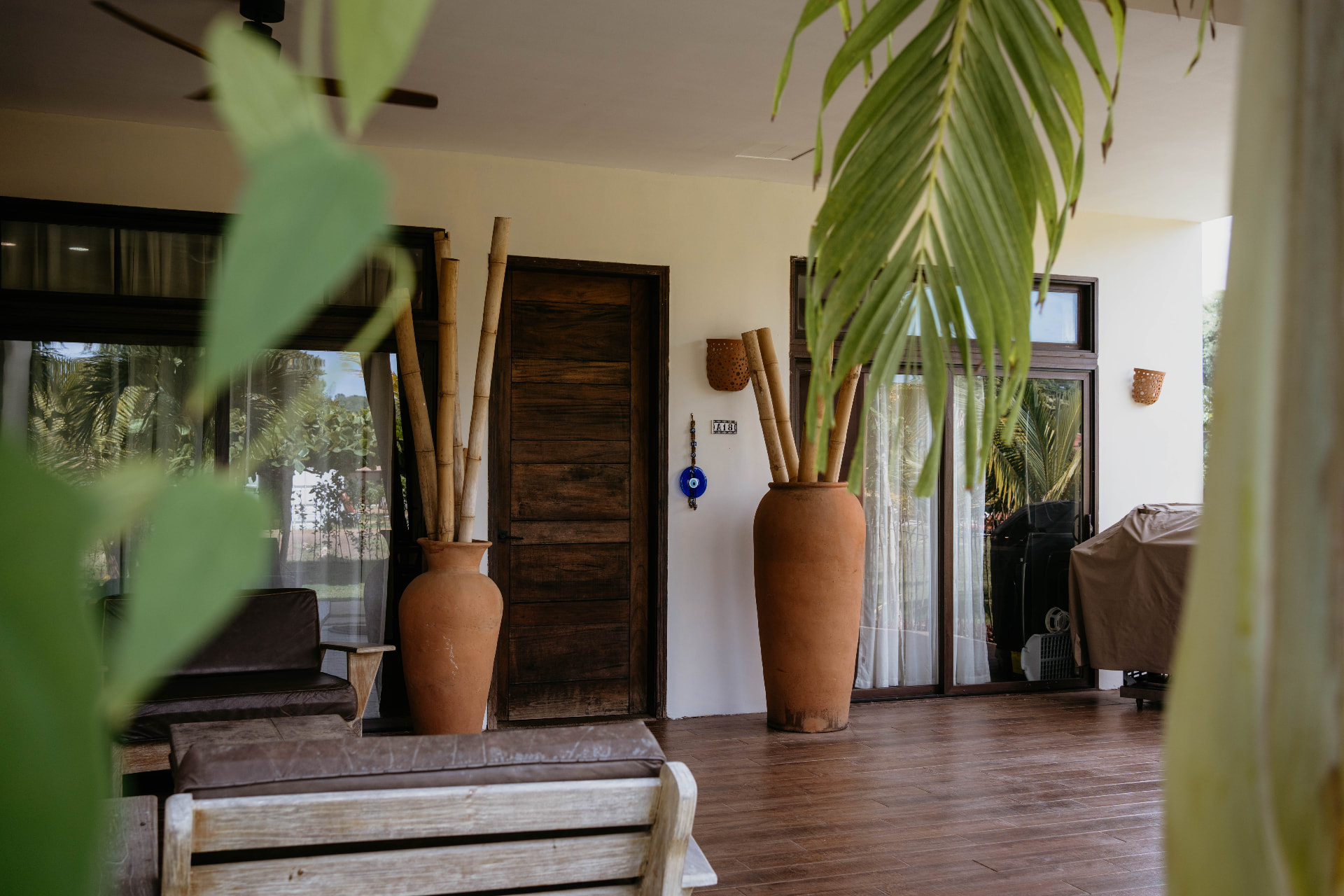 Apartment A18 — covered terrace with terracotta urns, bamboo and wooden door
