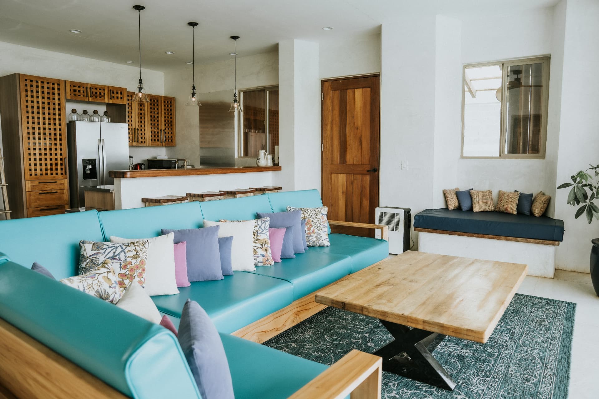 Villa Nomada — living room sofa, pendant lights and open kitchen behind