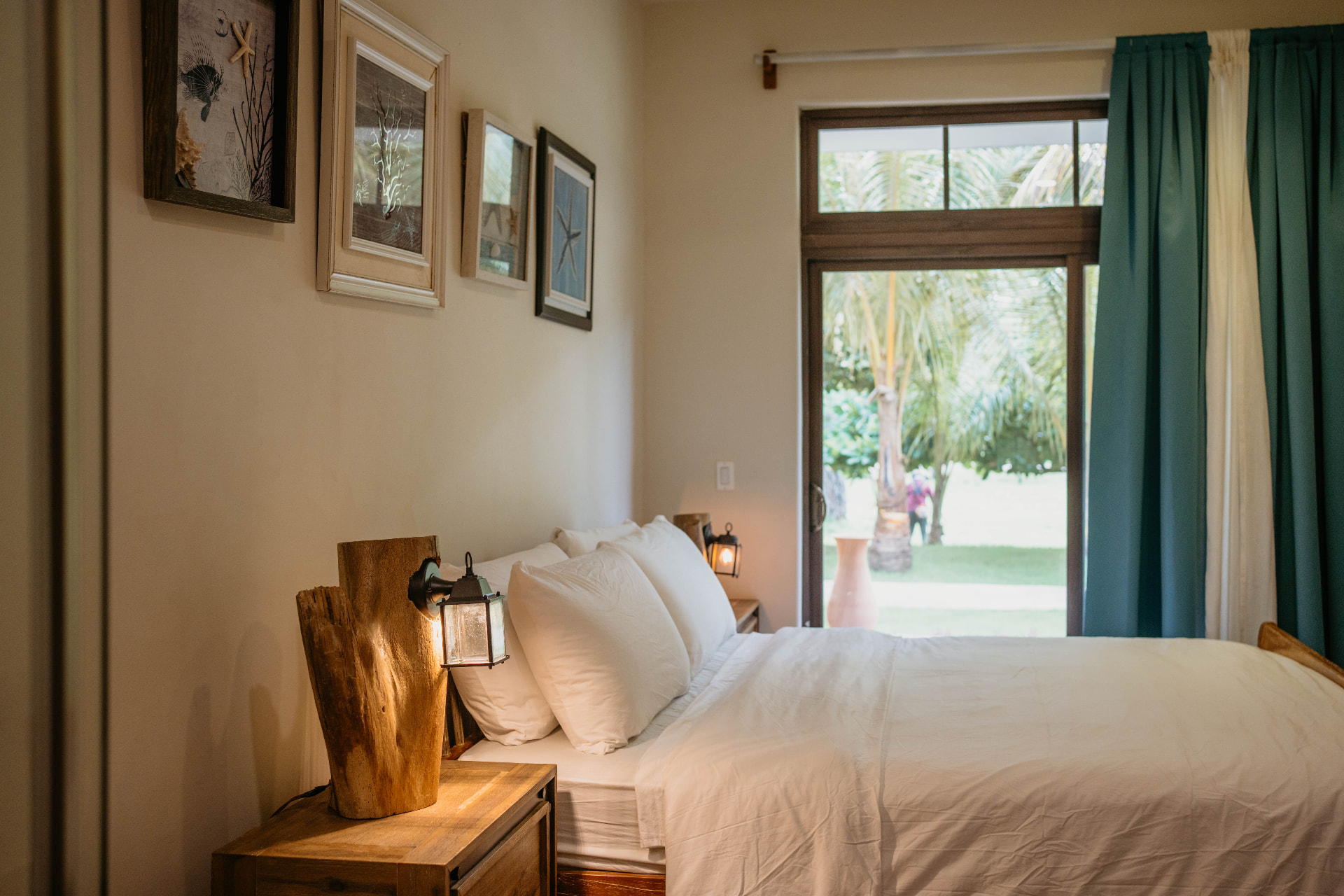 Apartment A18 — bedroom with framed prints and doors open to the garden