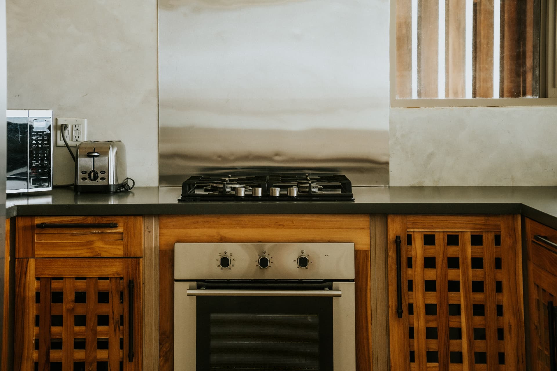 Villa Nomada — gas cooktop and oven set in teak cabinetry